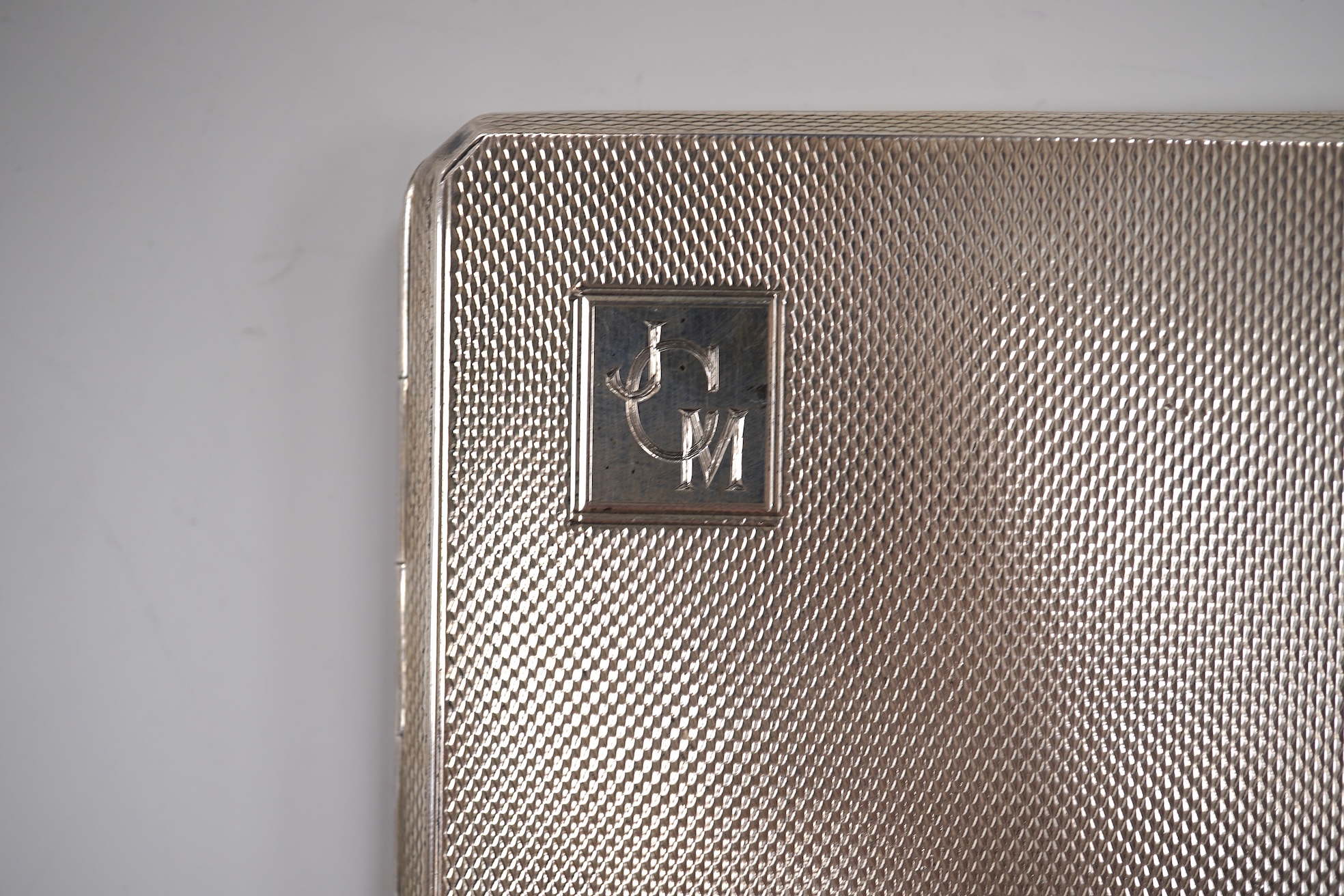A George V engine turned silver cigarette case by Smith & Bartlam, Birmingham, 1921, a pair of Edwardian silver single handled small dishes by Goldsmiths & Silversmiths Co Ltd and a silver egg cup.